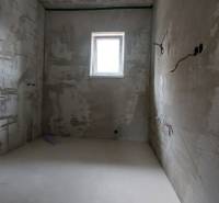 A room under construction with a window in a family house, electrical installation and walls without finishing.