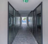 A glazed corridor with emergency lighting in commercial premises.