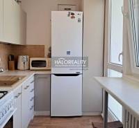 A kitchen in a 3-room apartment with a fridge, microwave, and stove.