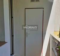 A balcony with white doors in a 3-room apartment, marked by a real estate agency.