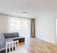 Living room with a corner sofa and a dining table in a 2-room apartment.