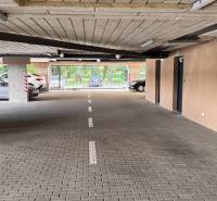 Interior of a garage with parking spaces and an exit to Sadová Street in Senica.