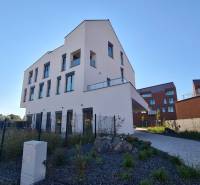 A new building on Perlová Street in Bratislava - Jarovce with modern windows and landscaped surroundings.