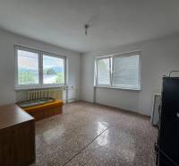 A simple room in a family house with a view through large windows.