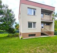 A family house in Nové Mesto nad Váhom with a garden and trees on a grassy area.