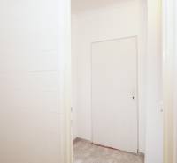 White doors in an office with tiled floors and white walls.