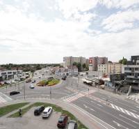 Roundabout with surroundings on Hlavná Street in Dunajská Streda, movement of cars, buildings, sky.