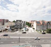 Traffic and buildings on Main Street in Dunajská Streda, office space.