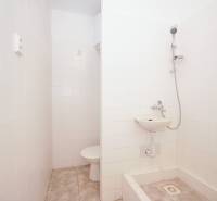 Bathroom with tiles, shower, and sink in the office.