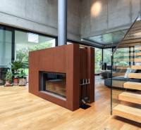 Interior of a family house with wooden stairs, a fireplace, and modern decorations.