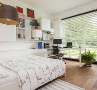 Bedroom with a work corner, wooden floor, garden view, library, family house.