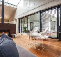 Living room with a fireplace in a family house, large windows overlooking the garden.