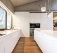 A kitchen in a family house with white cabinets and wooden flooring.