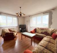 Living room of a family house with sofas, a television, and a table, bright atmosphere.