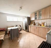 A kitchen in a family house with a dining table and a kitchen unit.