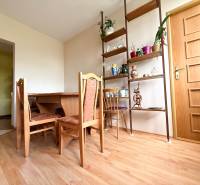 Dining room in a family house with a wooden table, chairs, and decorative shelves.