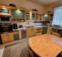 A kitchen in a family house with a wooden cabinet and a dining table.