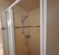 Shower enclosure in a family house with ceramic tiles and an adjustable showerhead.