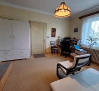 Living room in a family house with an armchair, a desk, and a dresser.
