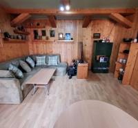 A cozy living room with wooden paneling, a couch, and a table in a family house.