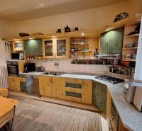 A kitchen in a family house with wooden cabinets and kitchen appliances.