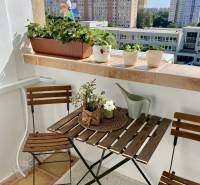 Balcony of a 3-room apartment with wooden furniture and a view of Petržalka.