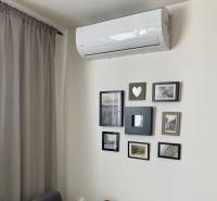 Air conditioning and framed photographs on the wall in a 3-room apartment.