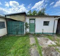 A family house in Trenčianske Stankovce with green doors, a small window, and a lawn.