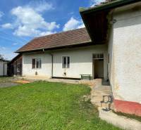 A family house in Trenčianske Stankovce with a lawn and a traditional roof under a blue sky.