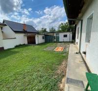 The garden of a family house in Trenčianske Stankovce with a green lawn and an extension.