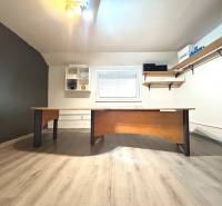 Office with a desk and shelves in a 4-room apartment, light flooring, minimalist design.
