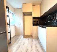 A kitchen in a 4-room apartment with wooden flooring, built-in appliances, and storage space.