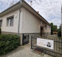 A family house in Topoľčianky with an entrance and gate on a gravel road.