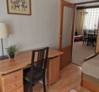 Home office with a desk, chair, and a view into the dining room.