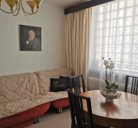 Interior of a family house with a dining table, an armchair, and a painting on the wall.