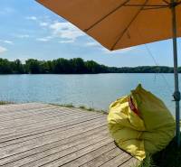 Wooden pier and bean bag under an umbrella by the lake in Vojka nad Dunajom.