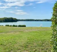 A peaceful body of water by a family house in Vojka nad Dunajom with greenery and an umbrella.