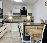 A kitchen in a family house, equipped with appliances, a dining table with chairs.