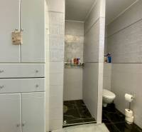 A bathroom in a family house with ceramic tiles and storage space.