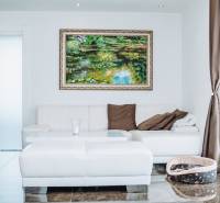 Living room in a family house with a white sofa, a painting, and a dog bed.