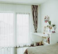 Bright bedroom with a desk and curtains, family house.