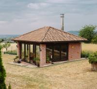 A family house in Kopanice in Krupina with a brick facade, glass walls, and a garden.