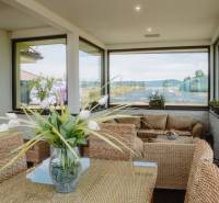 Wicker furniture in the sunroom of a family house with a view of the countryside.