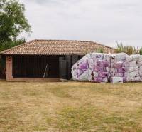 A family house in Kopanice in Krupina, storing building materials on dry grass.