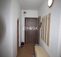 Entrance hallway in a 2-room apartment with light furniture and wooden doors.