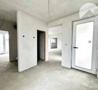 The interior of a family house under construction with unfinished walls and large windows.