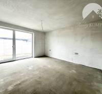 Empty interior of a family house with large glass doors and white walls.