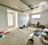 An unfinished interior of a family house with scattered building materials and new walls.