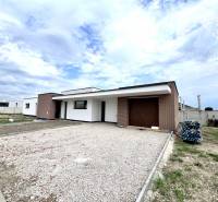 A family house in Miloslavov with a brick facade and a large parking lot, clear sky.
