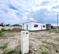 Building plot near a family house in Miloslavov with a visible electrical switchboard and a concrete fence.
